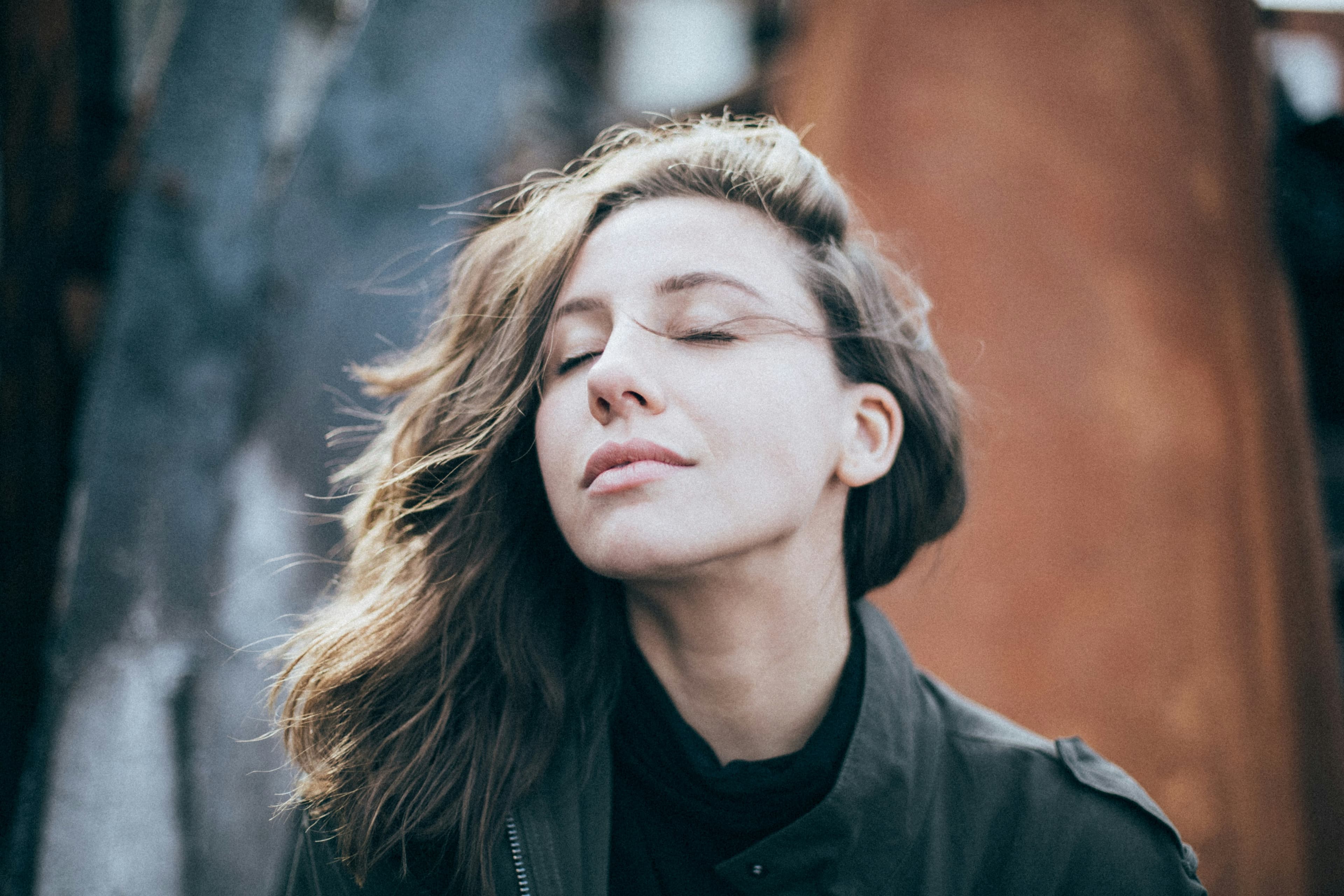 Woman with eyes closed and wind in her hair, taking a deep breath — signs you are ready for therapy